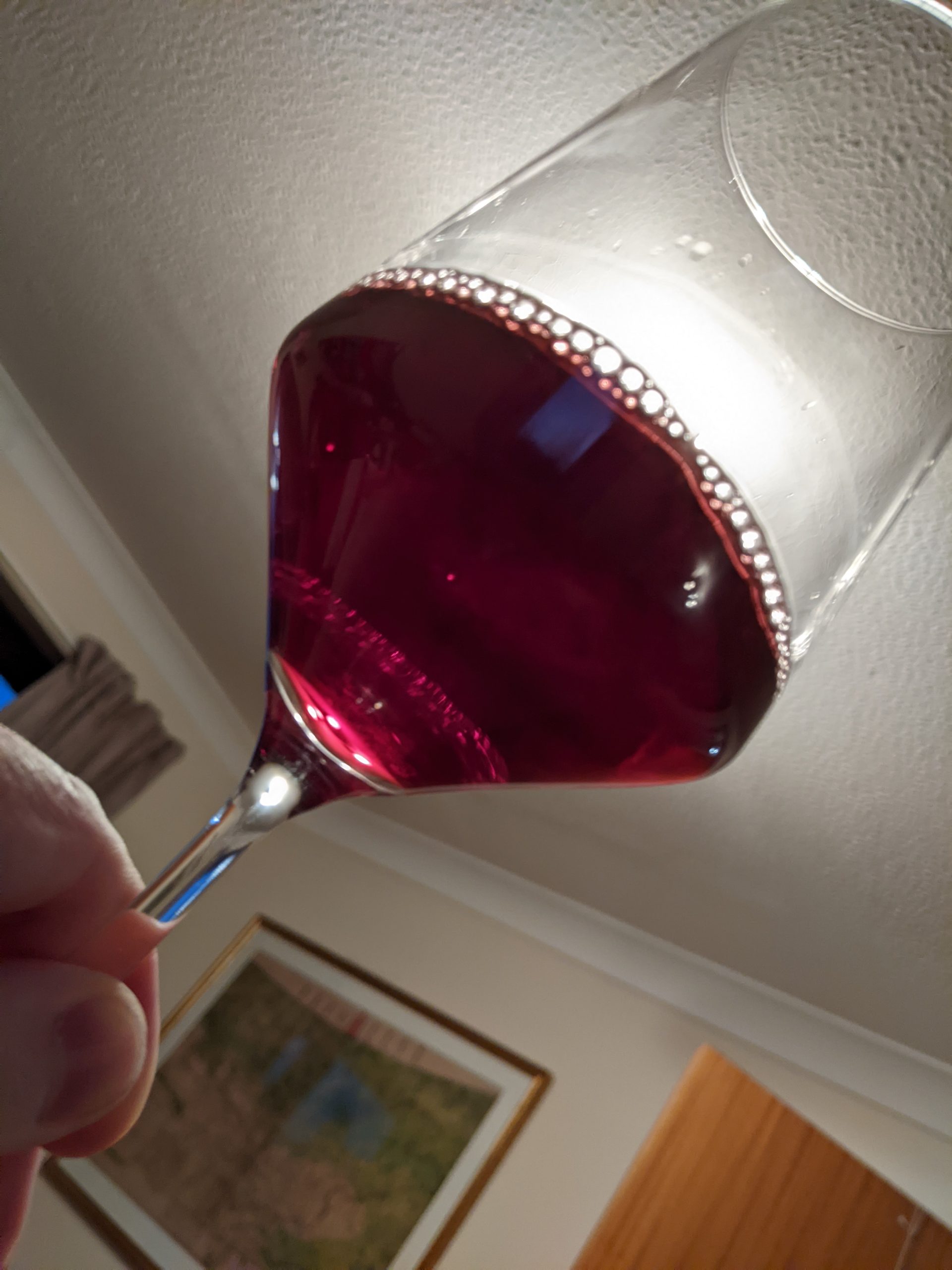 Glass of Dirupi Ole wine, held up to the light.